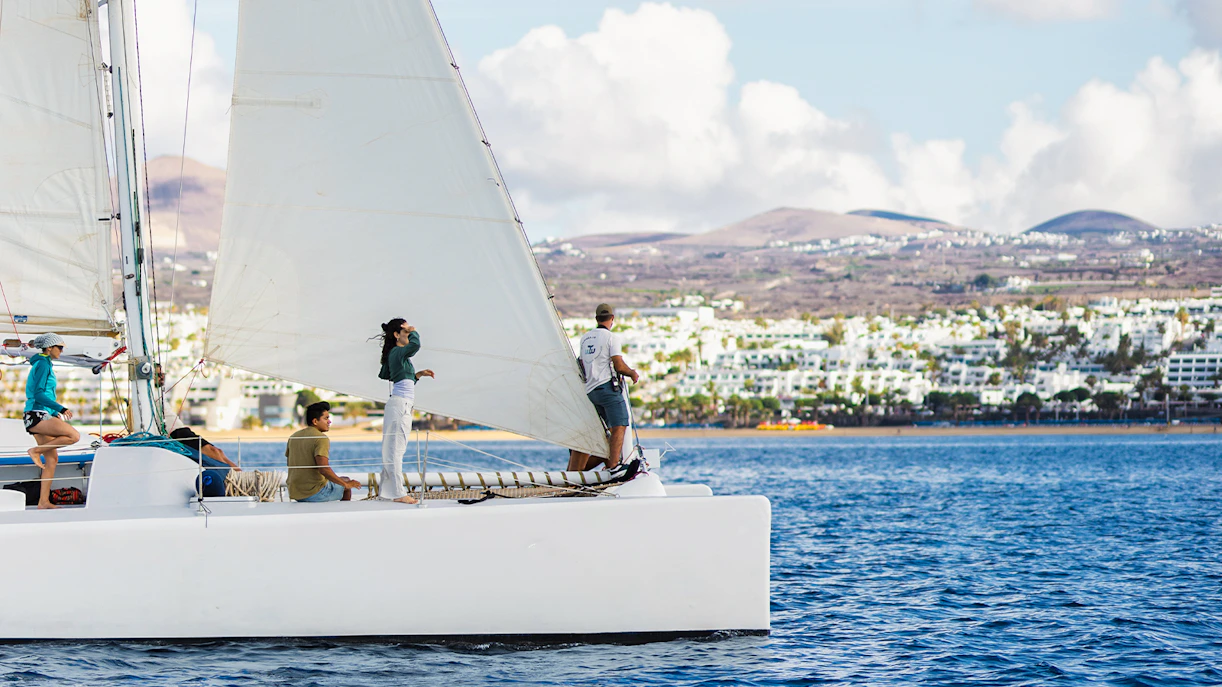 Tourists on a sailboat in Lanzarote waters, watching for whales and dolphins.