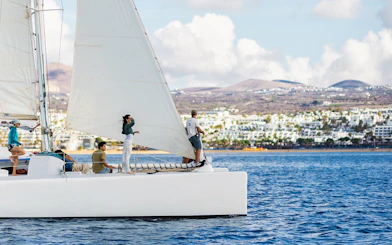 Tourists on a sailboat in Lanzarote waters, watching for whales and dolphins.