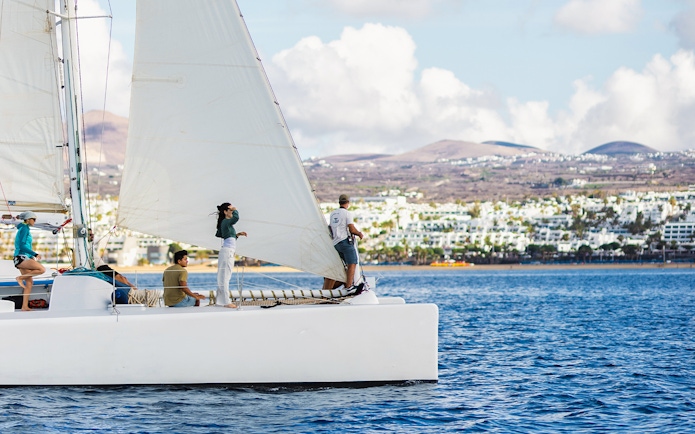 Tourists on a sailboat in Lanzarote waters, watching for whales and dolphins.