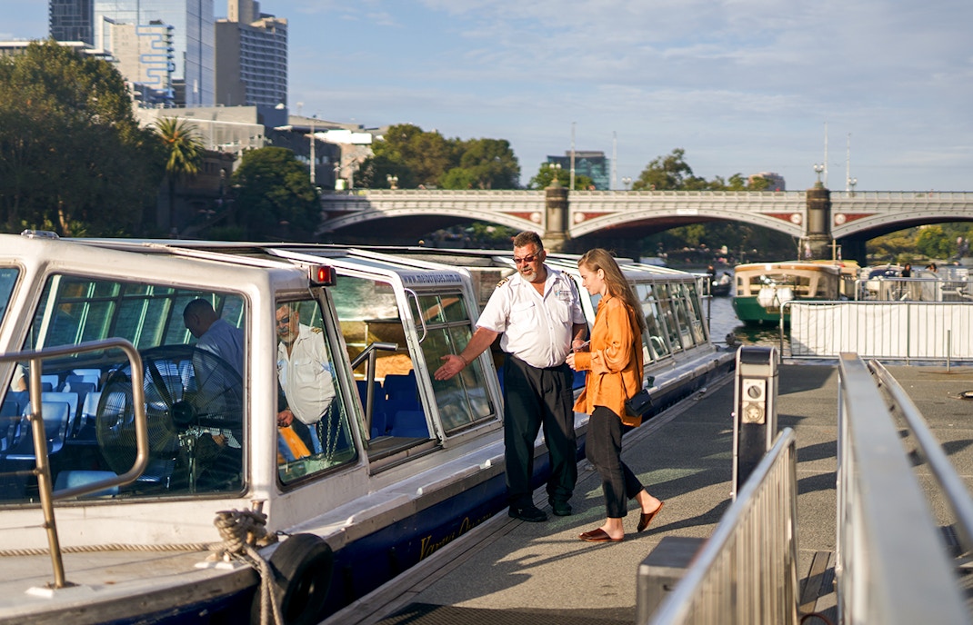 The cruise captain checking tickets of the guests on Sightseeing Cruise on Yarra River