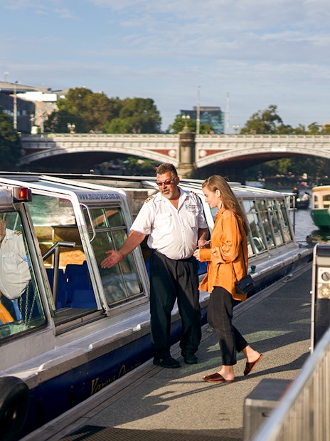 Cruise captain checking guest tickets on Yarra River sightseeing cruise in Melbourne.