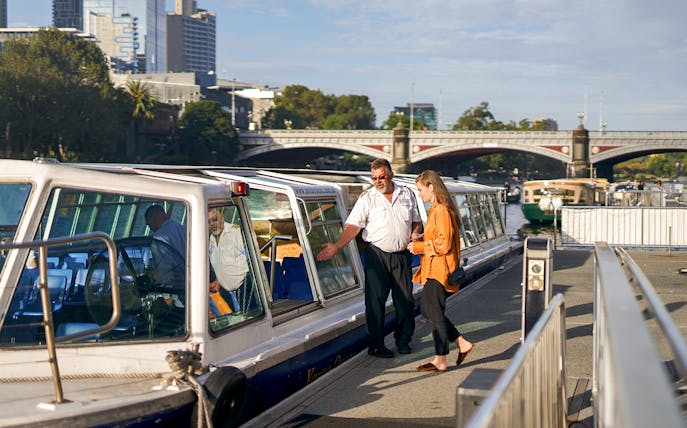 Cruise captain checking guest tickets on Yarra River sightseeing cruise in Melbourne.