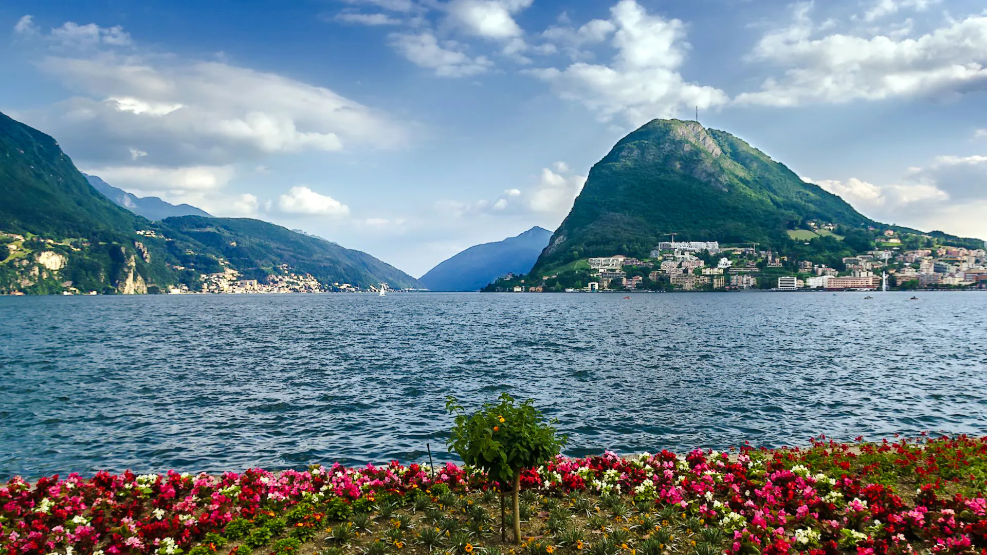 Lugano lake view with mountains and colorful flowers, Lugano Private Walking Tour.