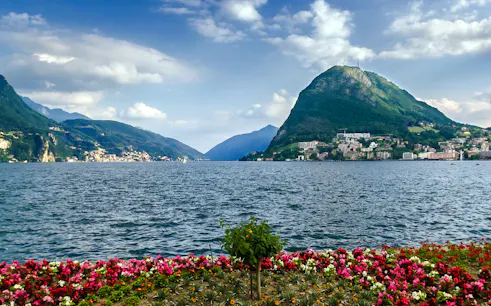 Lugano lake view with mountains and colorful flowers, Lugano Private Walking Tour.