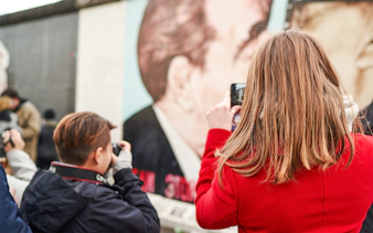Visitors photographing murals at Berlin's East Side Gallery.