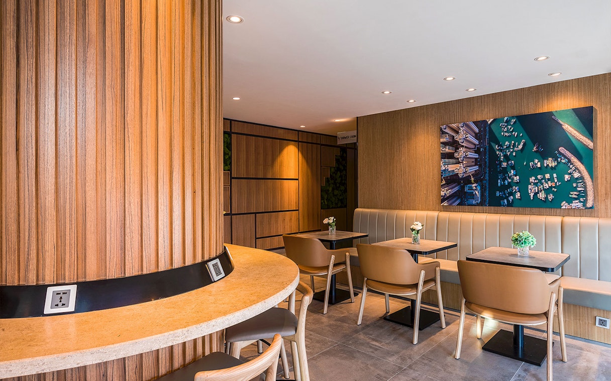Plaza Premium Lounge seating area with wooden decor and wall art.
