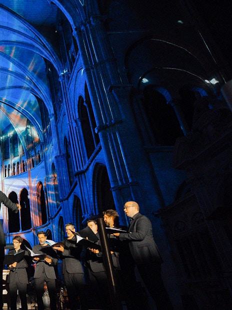 Choir performing under colorful lights at LUMINISCENCE Manchester 360° Immersive Show.