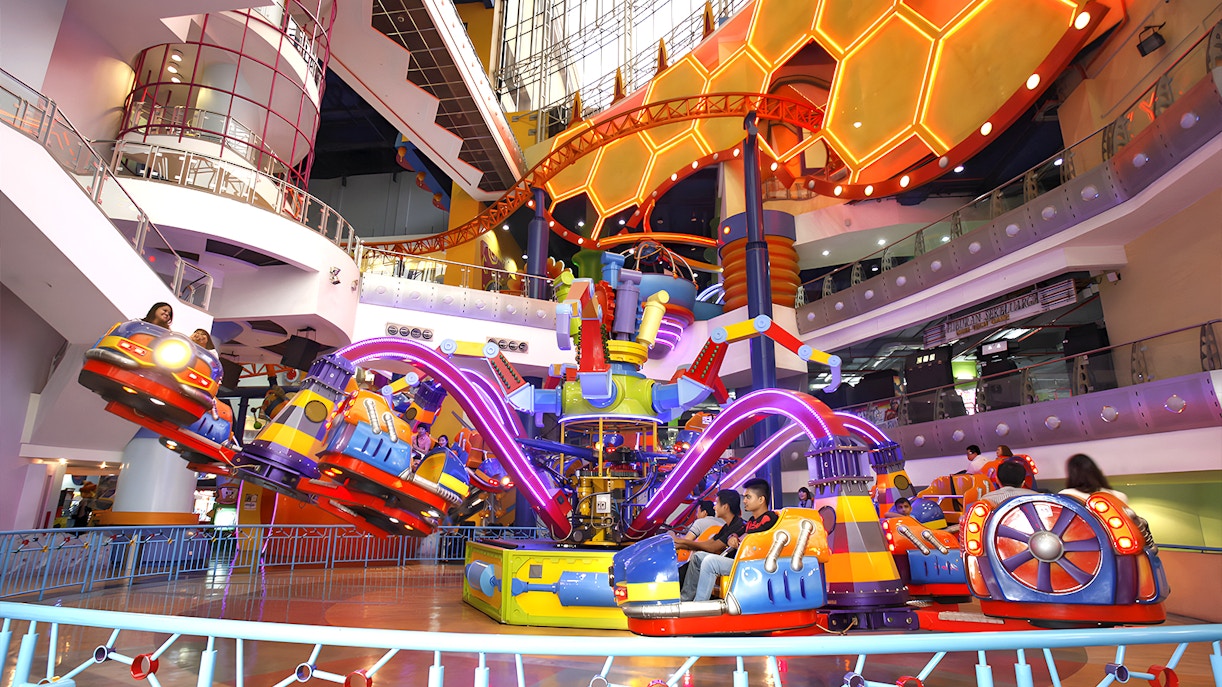 Berjaya Times Square Theme Park indoor ride with colorful cars and neon lights.