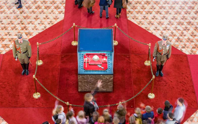 Hungarian Parliament crown jewels display with guards and visitors in Budapest.