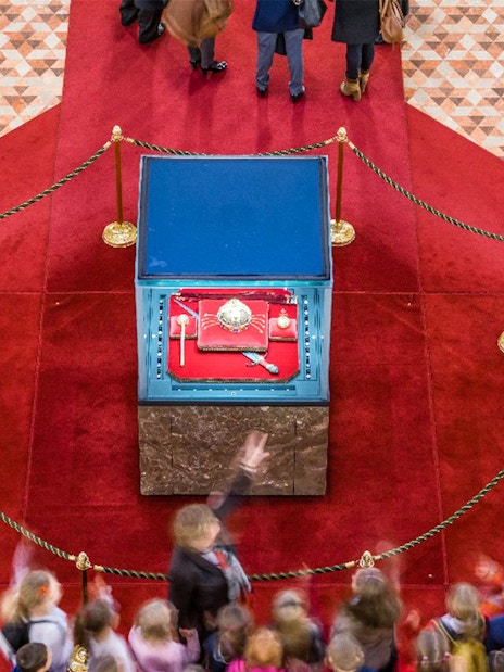 Hungarian Parliament crown jewels display with guards and visitors in Budapest.