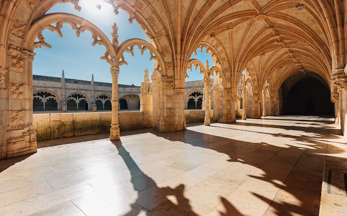 Gothic arches and stone columns inside Jerónimos Monastery, Lisbon.