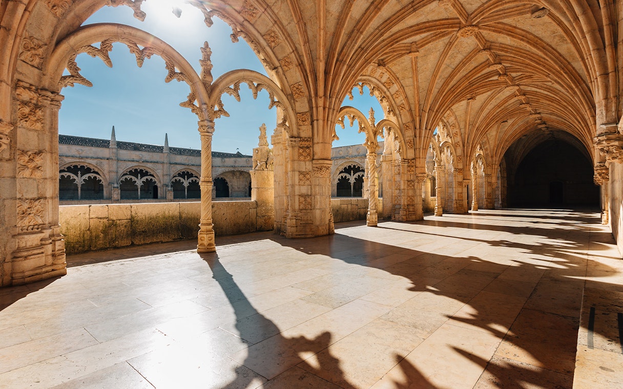 Gothic arches and stone columns inside Jerónimos Monastery, Lisbon.
