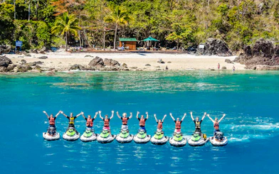 Tourists on jetskis in formation near Whitsundays beach, aerial view.