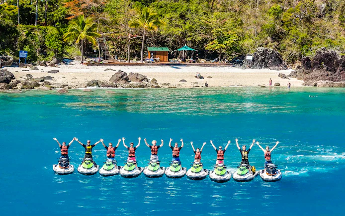 Tourists on jetskis in formation near Whitsundays beach, aerial view.