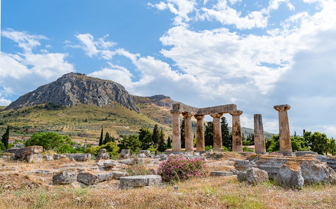 Temple of Apollo ruins at Ancient Corinth with Acrocorinth castle in the background.