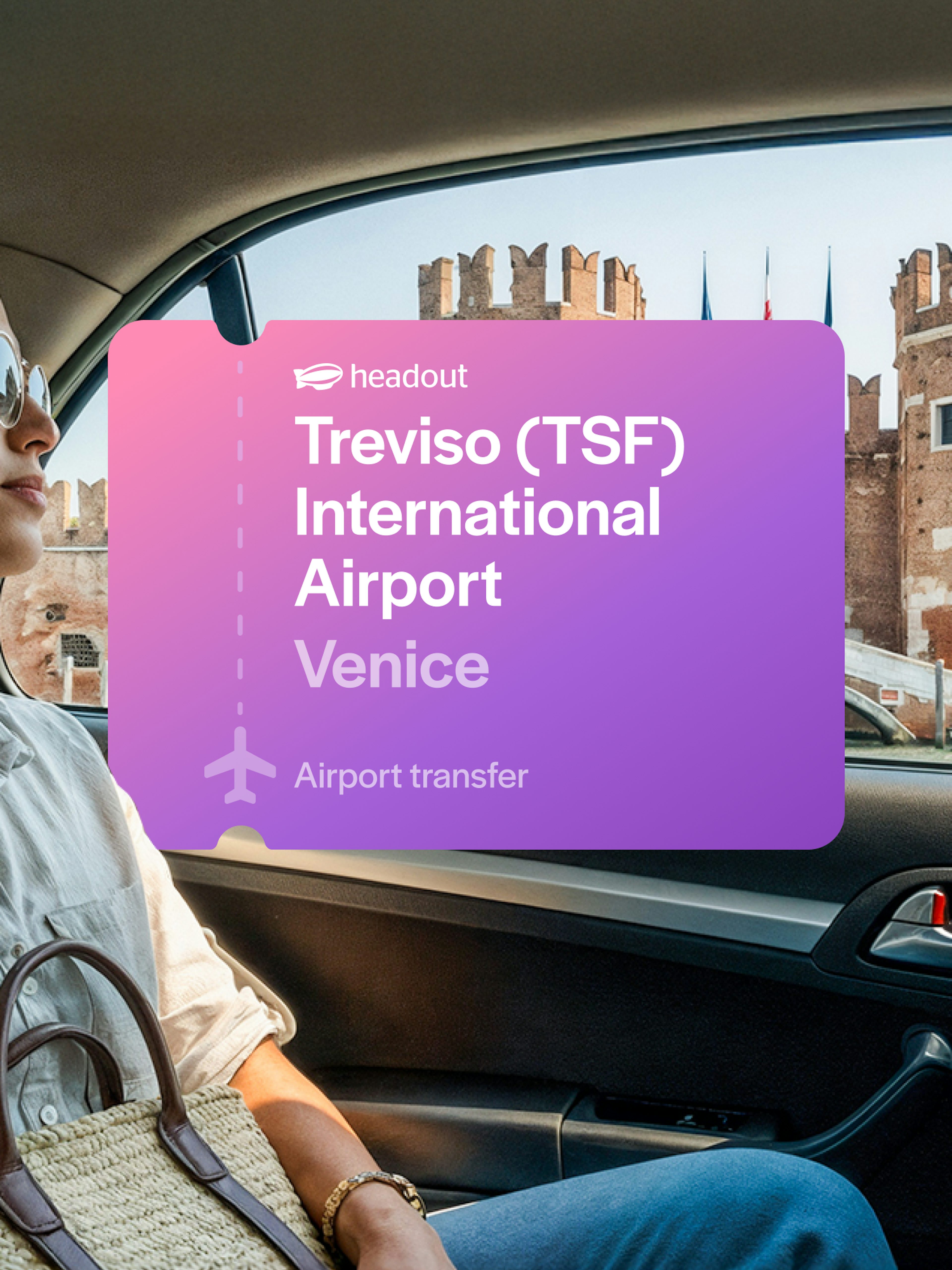 Woman in car with view of Venetian architecture, Treviso Airport transfer sign.