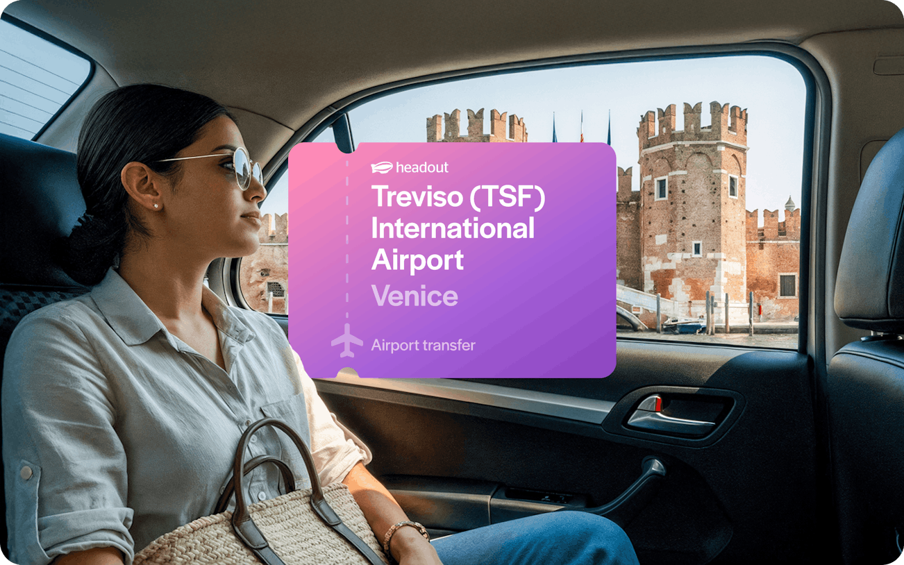 Woman in car with view of Venetian architecture, Treviso Airport transfer sign.