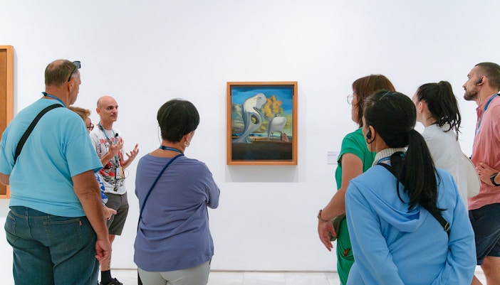 Tour guide explaining artwork to a group at the Reina Sofia Museum, part of the Prado & Reina Sofia Museum Guided Tour in Madrid, Spain