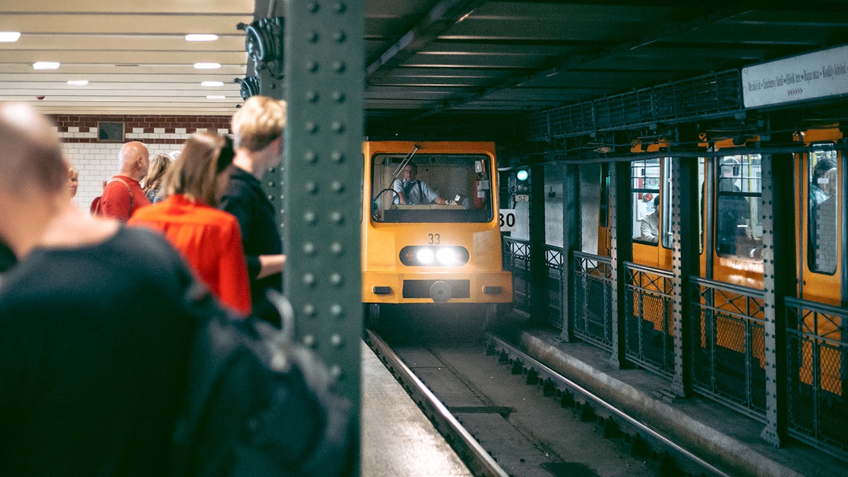 Historic Budapest metro station with vintage train on old subway line.