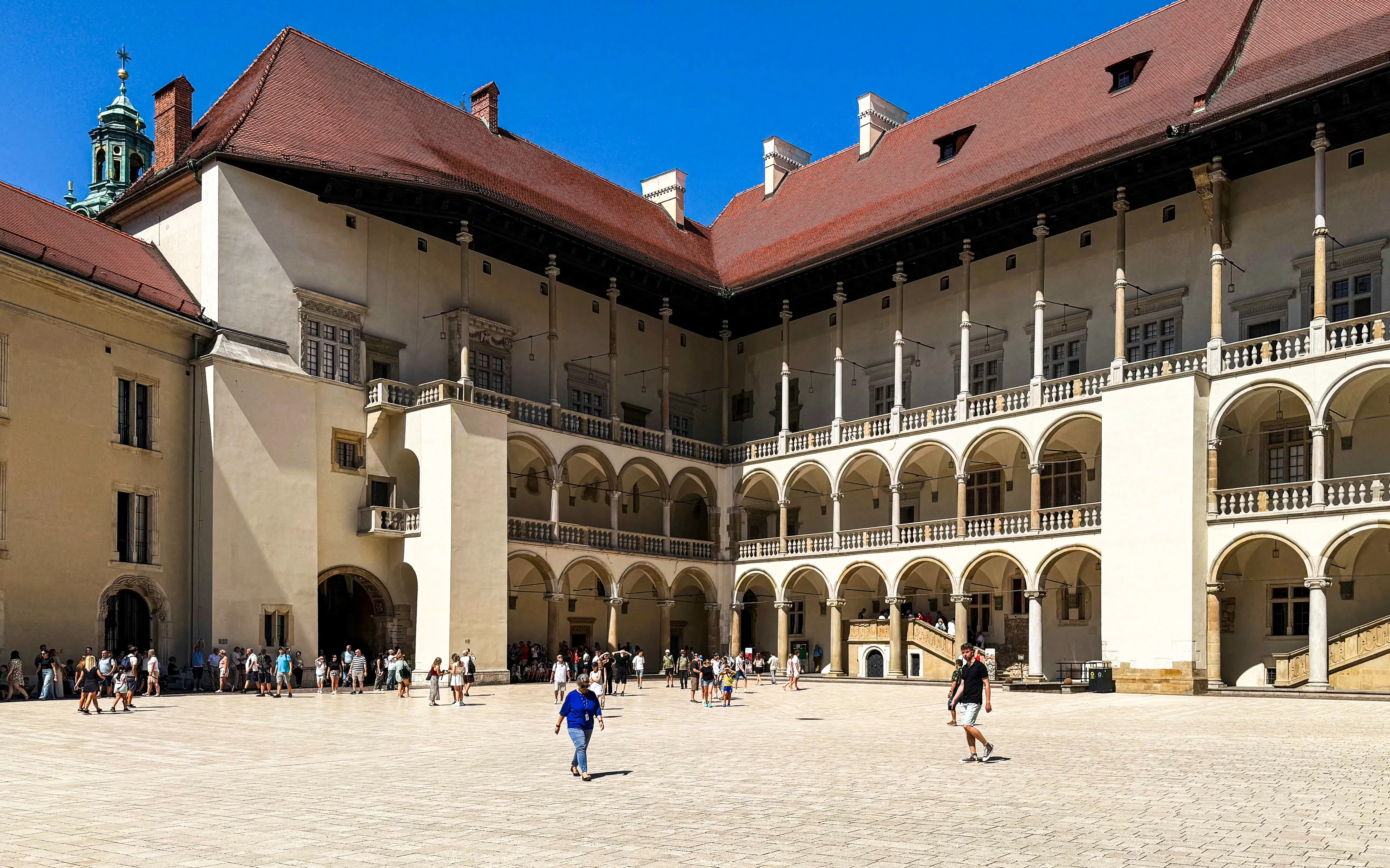 Courtyard of Wawel Royal Castle in Krakow with visitors exploring the historic architecture.