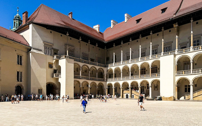 Courtyard of Wawel Royal Castle in Krakow with visitors exploring the historic architecture.