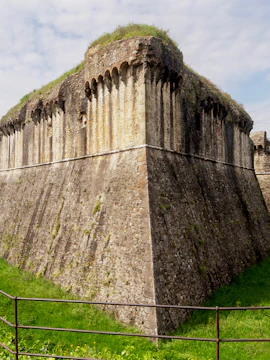 Fortezza di Sarzanello stone wall with grass-covered top in Sarzana, Italy.
