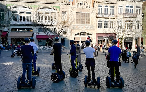 Riders on Segways exploring Porto's historic streets and landmarks during a guided city highlights tour.