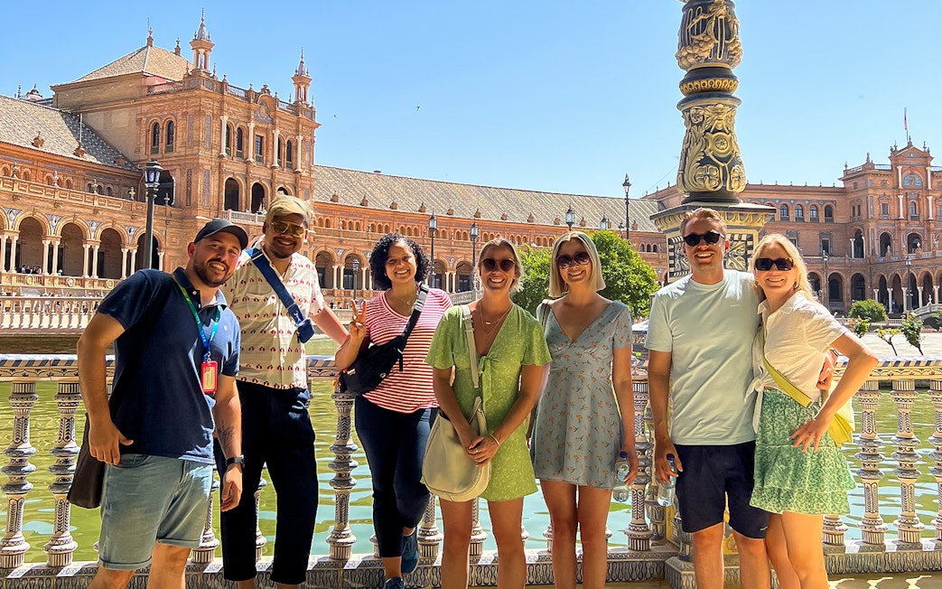 Tour group at Plaza de España, Seville, with historic architecture in the background.