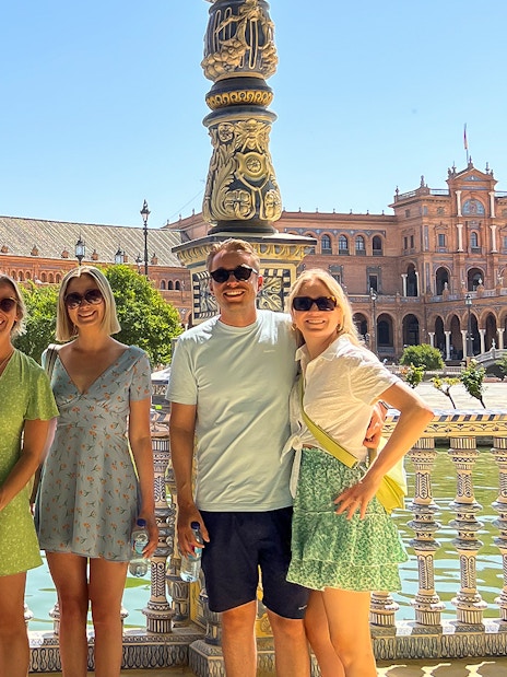 Tour group at Plaza de España, Seville, with historic architecture in the background.