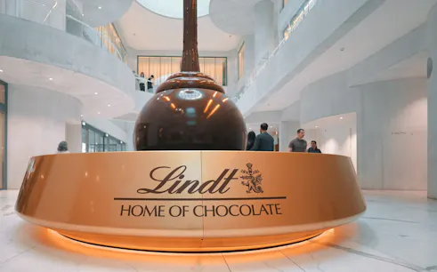 Lindt Chocolate Museum interior with large chocolate fountain centerpiece.