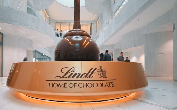 Lindt Chocolate Museum interior with large chocolate fountain centerpiece.