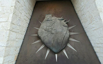 Stone heart sculpture with world map design, part of San Antonio's self-guided city exploration game.