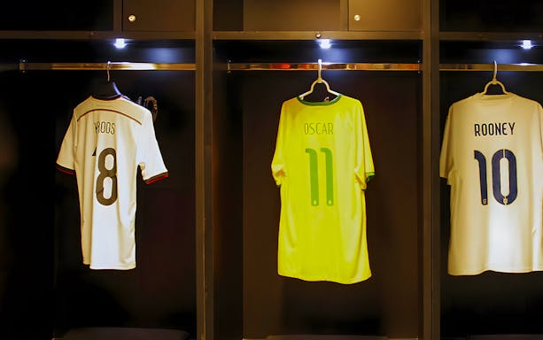 Jerseys of Kroos, Oscar, and Rooney hanging in a player dressing room.