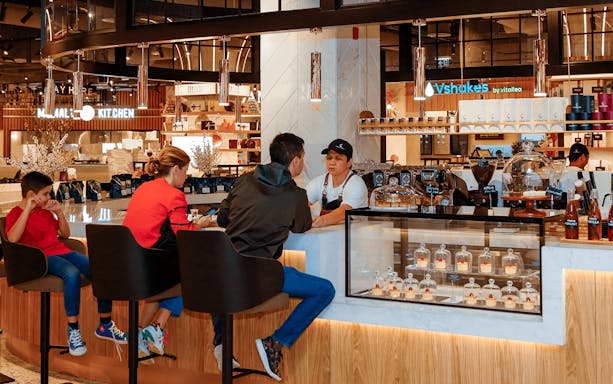 Bar counter at Depachika, View at the Palm, with people seated and a server behind the counter.