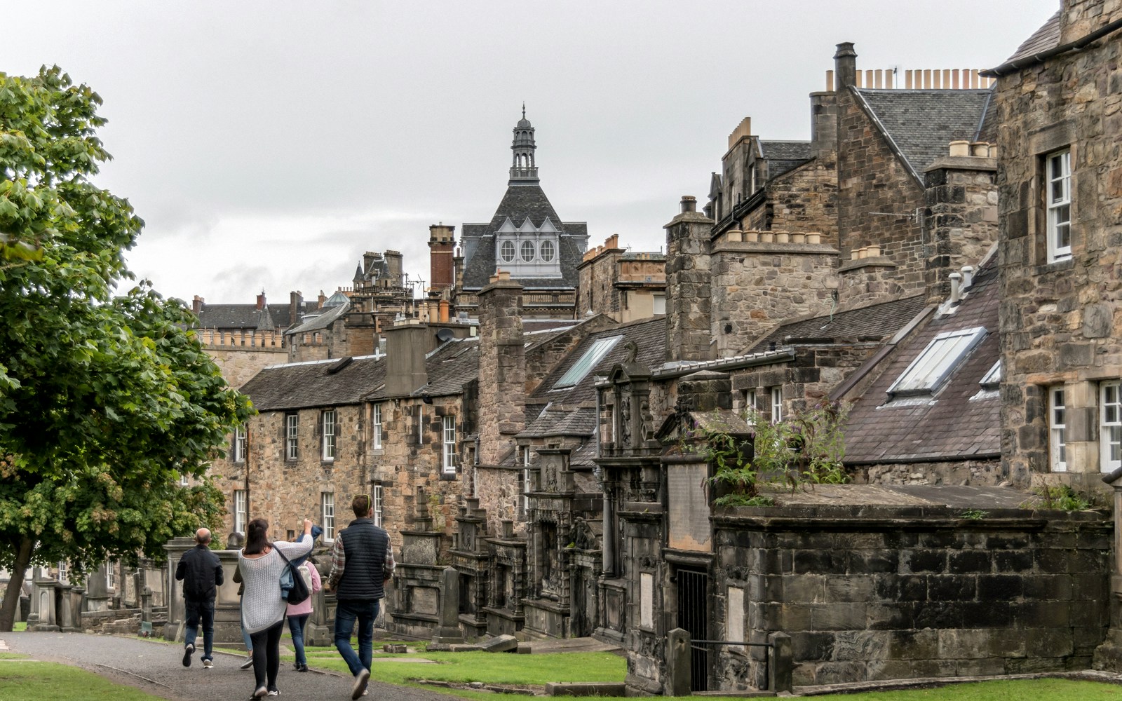 Tour guide leading a group of tourists to Greyfriars Kirkyard in Edinburgh