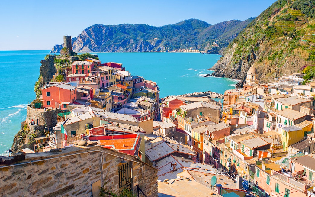 Colorful houses on a cliffside in Vernazza, Cinque Terre, overlooking the Ligurian Sea.