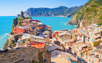 Colorful houses on a cliffside in Vernazza, Cinque Terre, overlooking the Ligurian Sea.