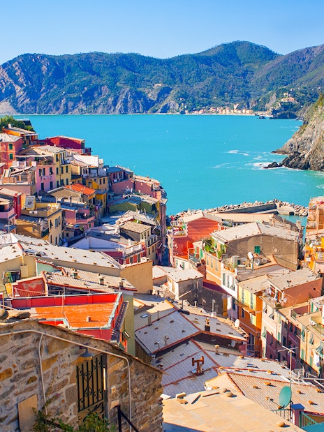 Colorful houses on a cliffside in Vernazza, Cinque Terre, overlooking the Ligurian Sea.