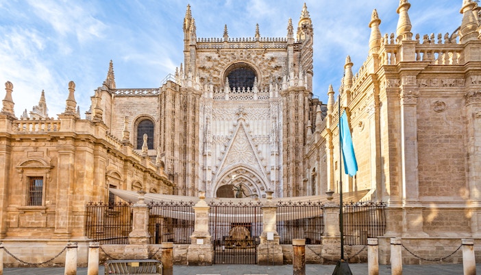 Seville Cathedral exterior with Giralda tower, showcasing Gothic architecture in Seville, Spain.