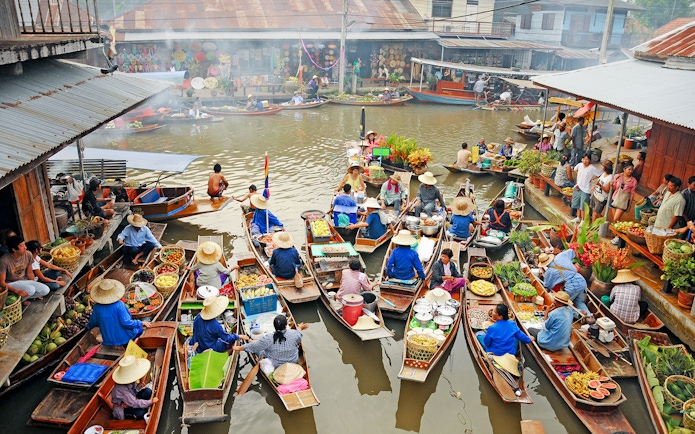 Boats with vendors selling goods at Amphawa Floating Market, Thailand.