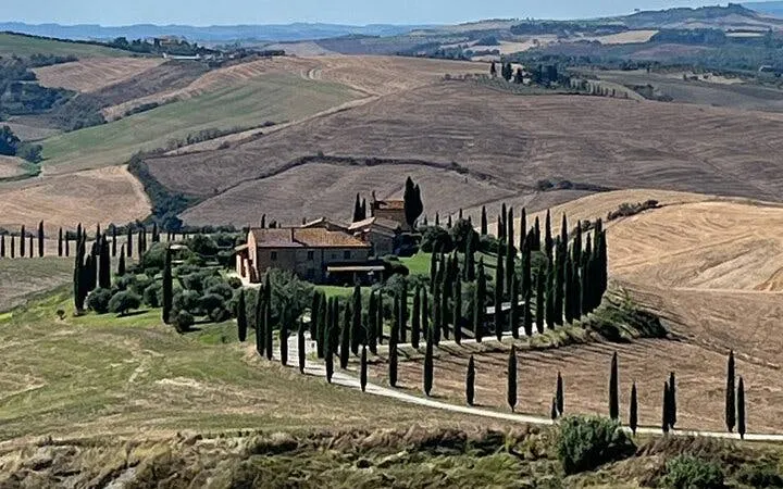 Tuscan villa surrounded by cypress trees in Val d'Orcia, Italy.