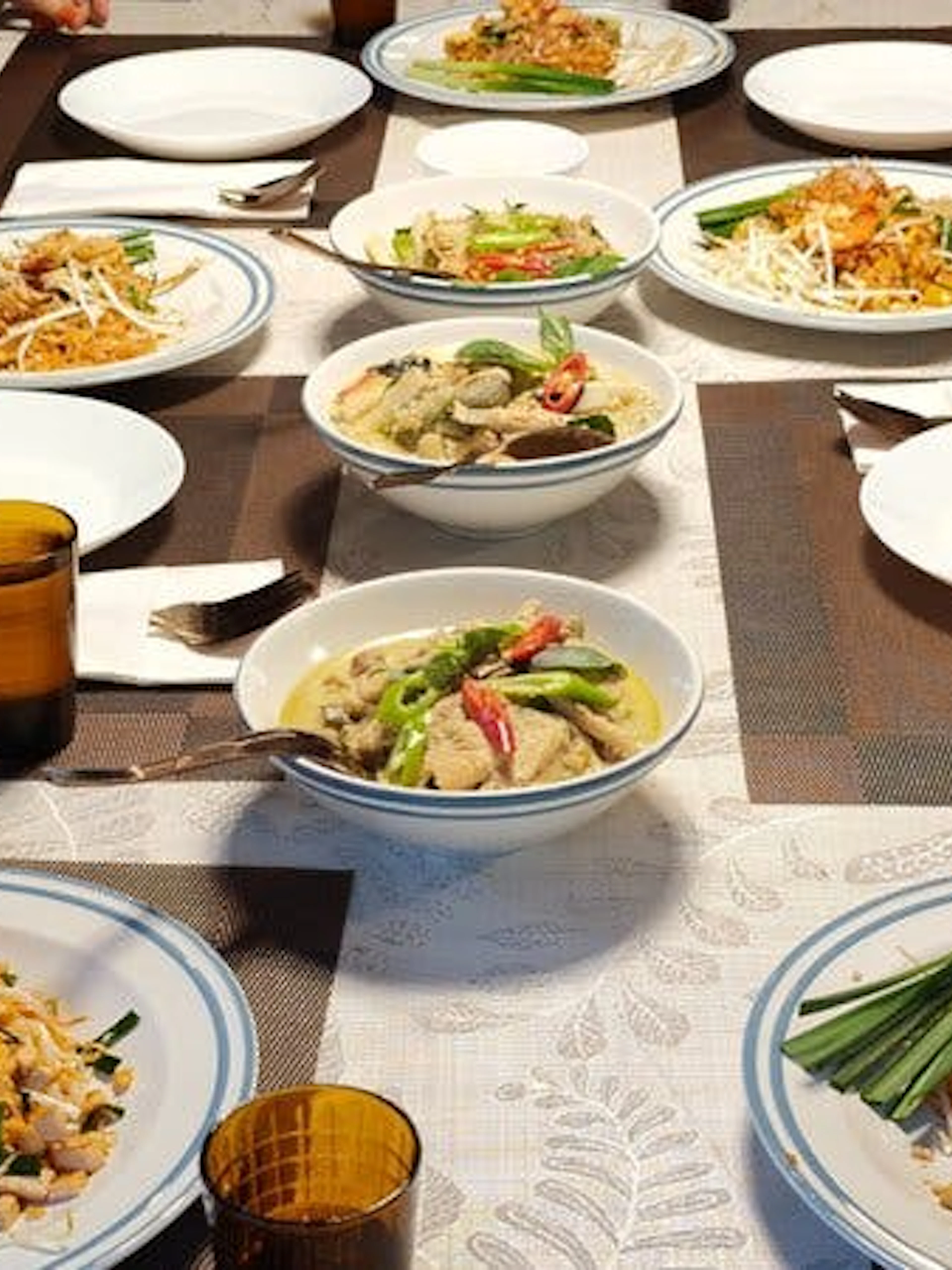Thai dishes on a table during a cooking class with market visit and boat ride at a historic garden house.