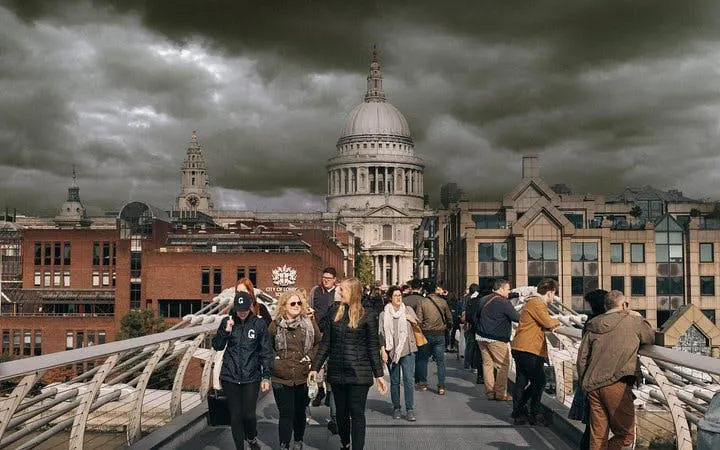 Walking tour on Millennium Bridge with view of St. Paul's Cathedral, London.
