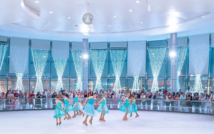 Ice skaters performing at Soho Square Ice Rink, Sharm El Sheikh, with an audience watching.