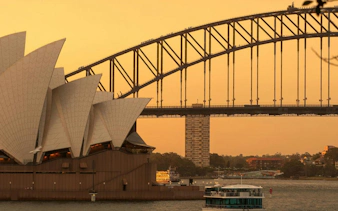 Sydney Opera House and Harbour Bridge at sunset, view from The Rocks, Sydney.
