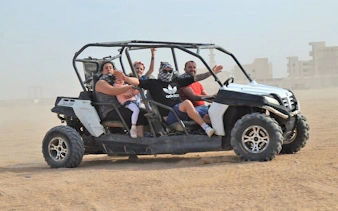 Group enjoying buggy ride in Sharm El Sheikh desert during sunrise or sunset safari.
