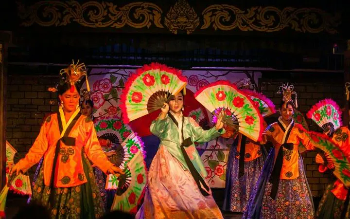 Performers with colorful fans at Blue Dragon Cabaret in Krabi, Thailand.