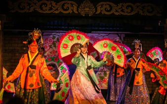 Performers with colorful fans at Blue Dragon Cabaret in Krabi, Thailand.