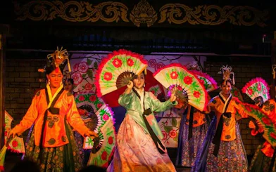 Performers with colorful fans at Blue Dragon Cabaret in Krabi, Thailand.
