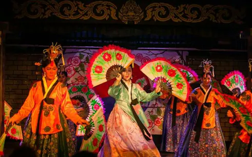 Performers with colorful fans at Blue Dragon Cabaret in Krabi, Thailand.